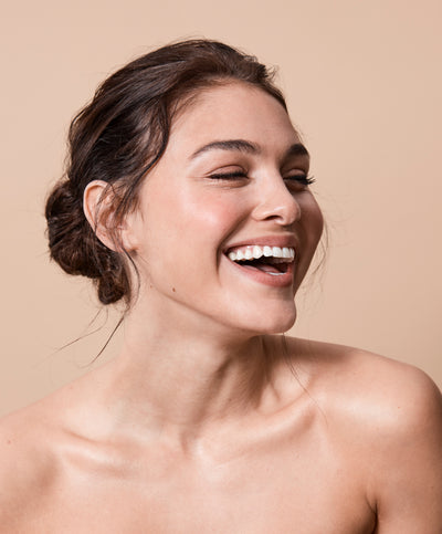 your beysis model smiling on a peach background