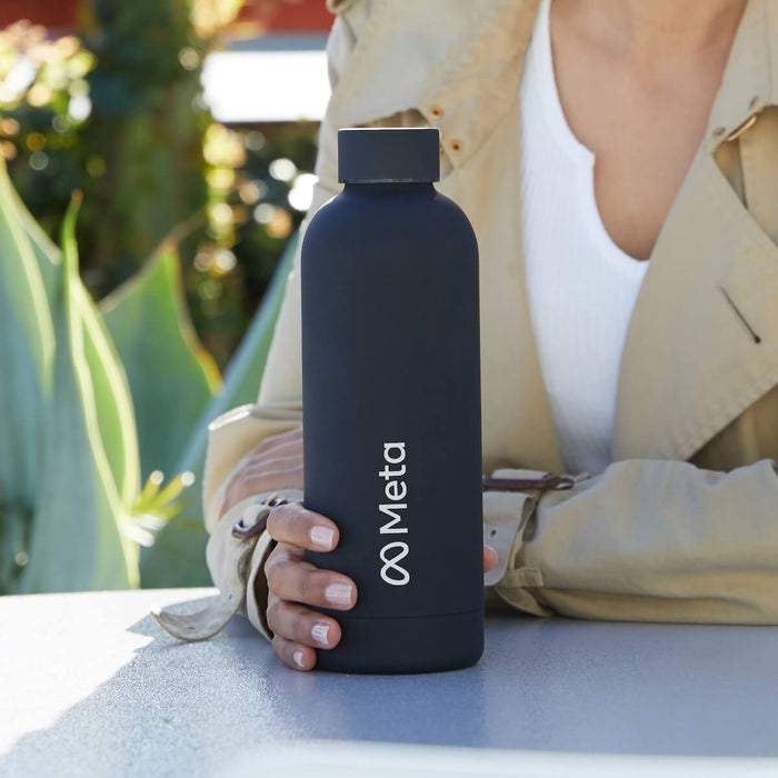 Beysis navy 500ml stainless steel water bottle branded with a company logo, held on an outdoor table